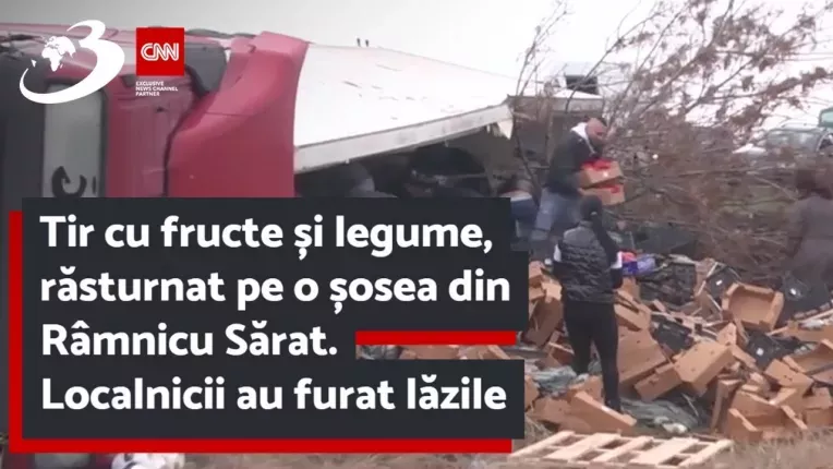 Tir cu fructe si legume, rasturnat pe o sosea din Ramnicu Sarat. Localnicii au furat lazile